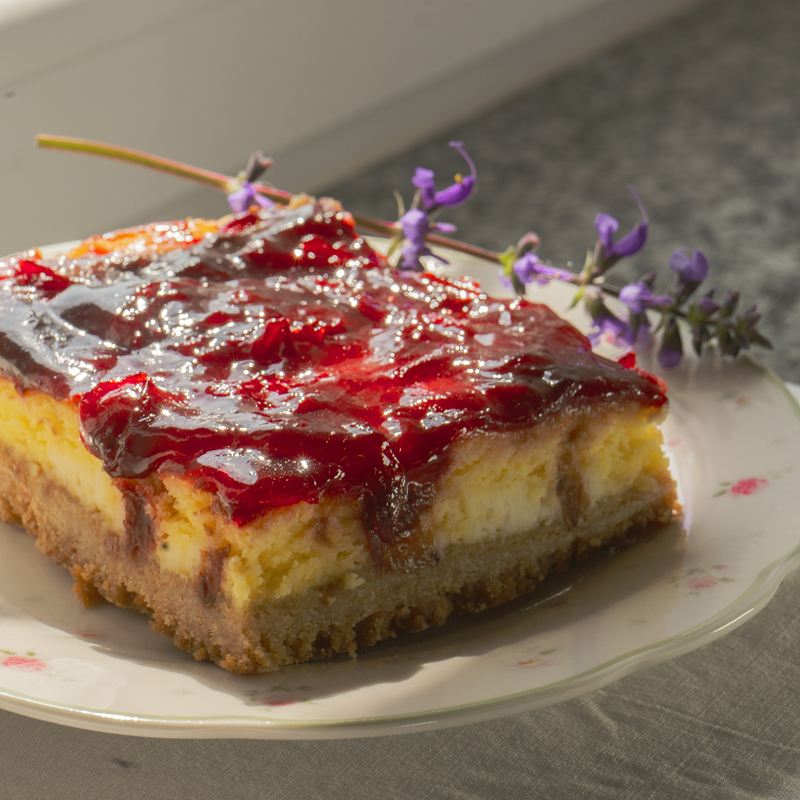 Una fetta di cheesecake con la confettura di ciliegie