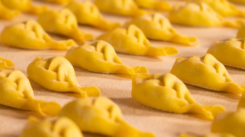 File di tortelli con la coda appena chiusi a mano
